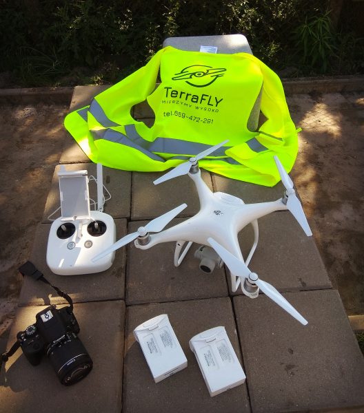 Dron, baterie, aparat fotograficzny i kamizelka ofblaskowa